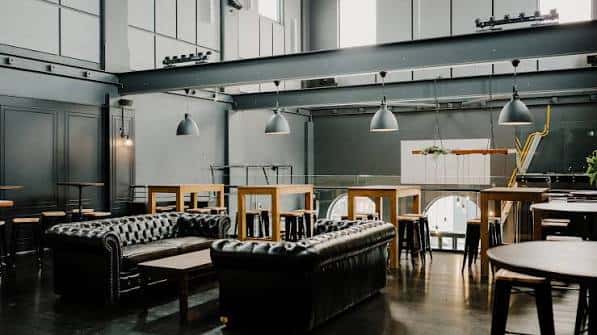Interior espacioso del Meantime Brewing con sofás de cuero y mesas altas