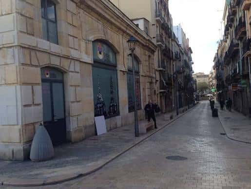 Vista de la calle Cós del Bou en Tarragona con edificios históricos y adoquines