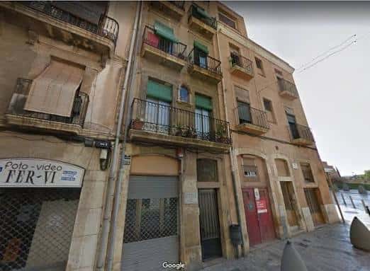 Fachada de edificio tradicional en Carrer del Cós del Bou con balcones y ventanas