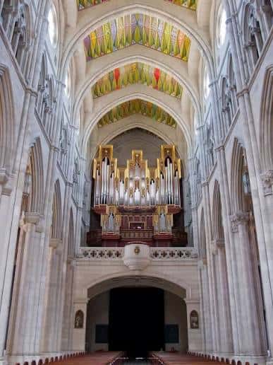 Interior de la catedral mostrando el gran órgano y bóvedas decoradas con vitrales coloridos