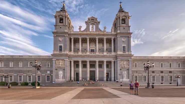 Plaza frente a la Catedral de la Almudena con visitantes y arquitectura monumental al atardecer