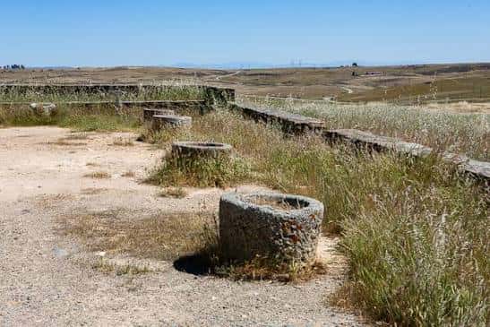 Vista de las ruinas del campamento romano con muros de piedra y entorno natural