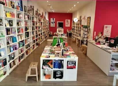Interior de la librería con estanterías llenas de libros y zona de lectura