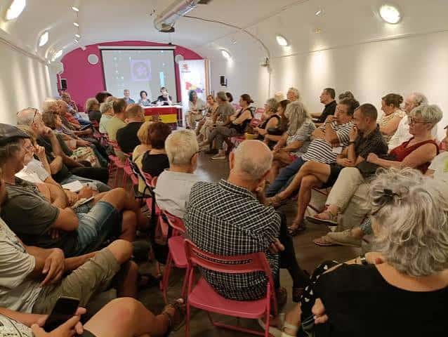 Evento en el interior del Centro Social con público asistiendo a una presentación