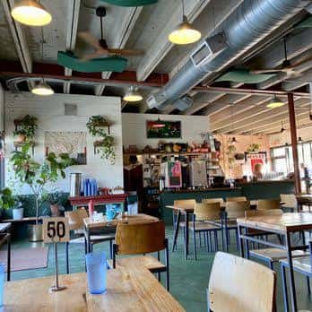 Interior del restaurante Kinda Tropical con mesas y decoración tropical