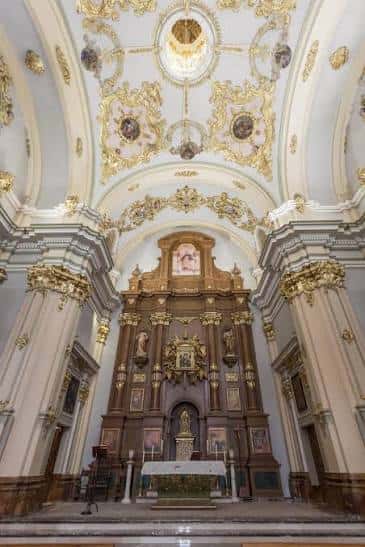Interior del oratorio con retablo barroco dorado y bóveda decorada
