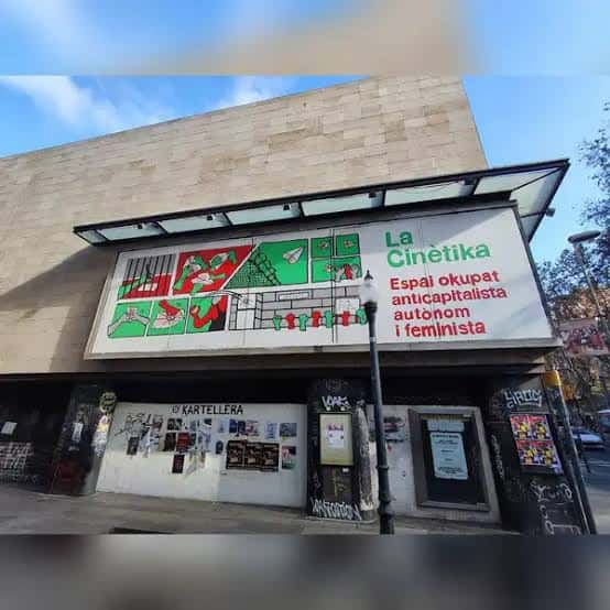 Fachada de La Cinètika con cartel de arte gráfico y letrero verde