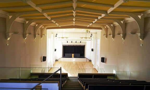 Vista general del Memorial Hall desde la galería superior, mostrando el escenario y las butacas