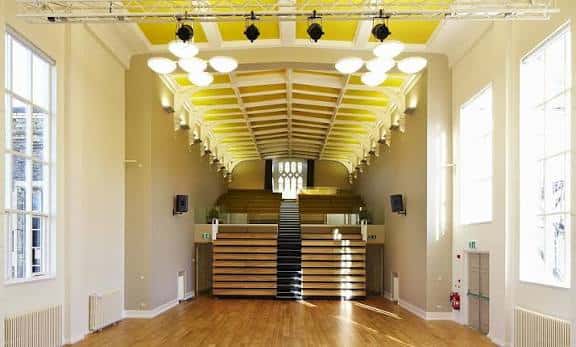 Interior del salón principal con suelo de madera y techo abovedado iluminado