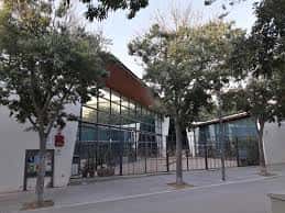 Vista exterior del Centre Cívic Font de la Guatlla con fachada de cristal y techo inclinado