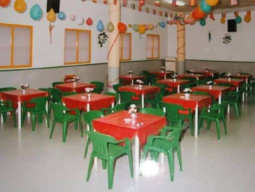 Sala de eventos decorada con mesas y sillas para celebración