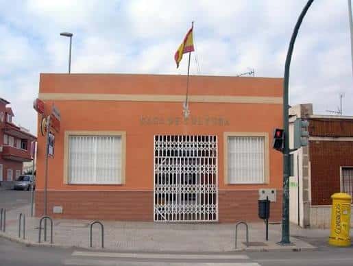 Casa de Cultura con bandera española y rejas blancas