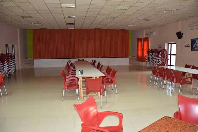Sala de eventos con mesas y sillas dispuestas para una reunión o cena