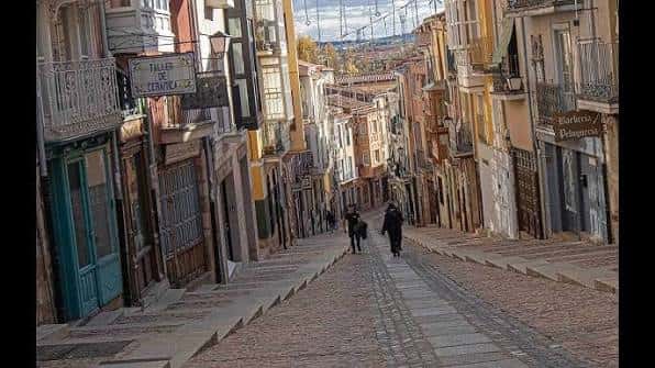 Calle empedrada de Balborraz con personas caminando y arquitectura típica zamorana