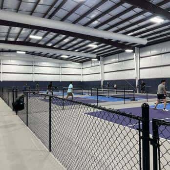 Pistas de pickleball desde una perspectiva lateral con vallas de seguridad