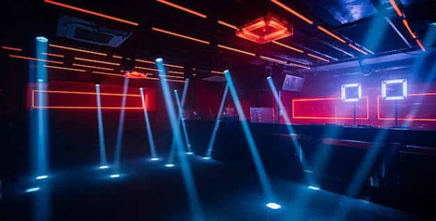 Interior del club con iluminación LED azul y roja, sin público