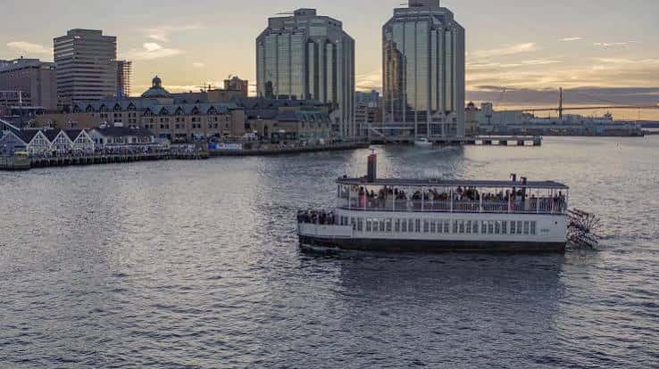 El Harbour Queen I en el agua frente a los rascacielos de Halifax durante la puesta de sol