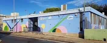 Vista exterior del Polideportivo Molino Derribao con murales coloridos