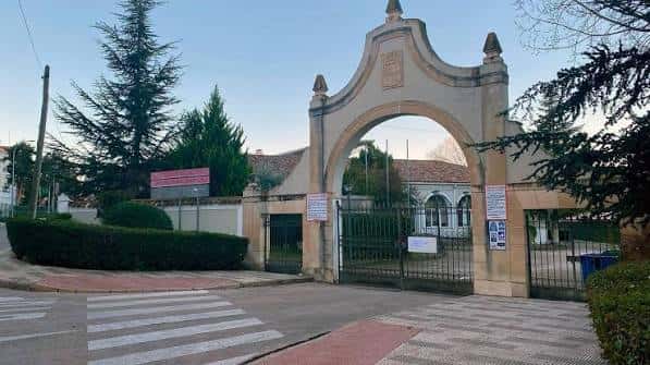 Entrada monumental al recinto con arco clásico y portones metálicos