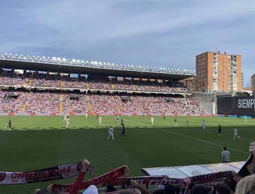 Vista del campo de juego con gradas llenas y ambiente festivo