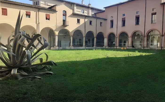 Vista del patio interior con césped y escultura metálica