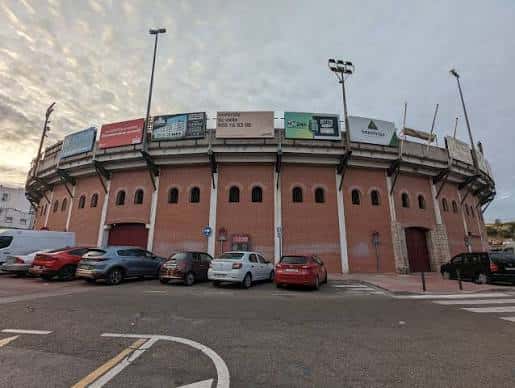 Vista exterior de la Plaza de Toros de San Sebastián de los Reyes con fachada de ladrillo y anuncios publicitarios
