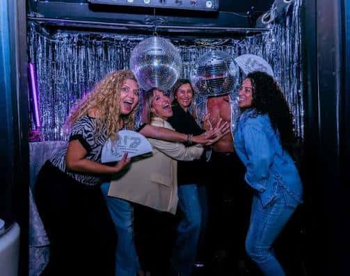 Clientes posando con pancartas en el interior decorado del club N29