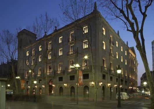 Vista nocturna del edificio principal del Hotel 1898 iluminado
