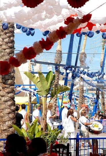 Vista de la Feria de Melilla con decoraciones festivas y público disfrutando del ambiente