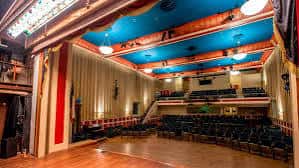 Interior del teatro desde el escenario mostrando butacas y balcones