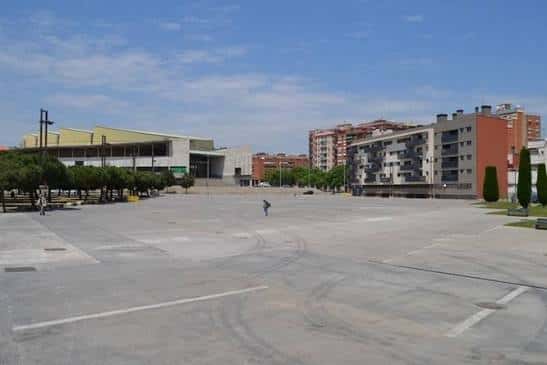 Vista diurna de la Plaça del President Tarradellas con edificios residenciales y comerciales al fondo