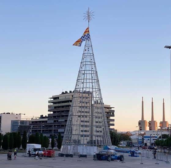 Árbol de Navidad metálico en construcción durante el atardecer en la plaza