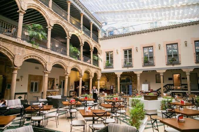 Patio interior histórico del hotel con arcos y zona de estar