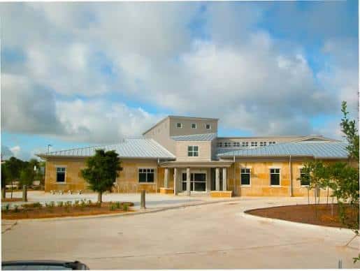 Vista exterior de la biblioteca Ruiz Branch con fachada moderna y cielo nublado
