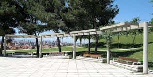 Área de descanso con pérgolas y bancos en el parque, ideal para eventos al aire libre
