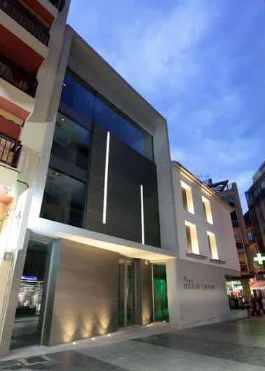 Vista nocturna de la fachada moderna del museo con iluminación arquitectónica