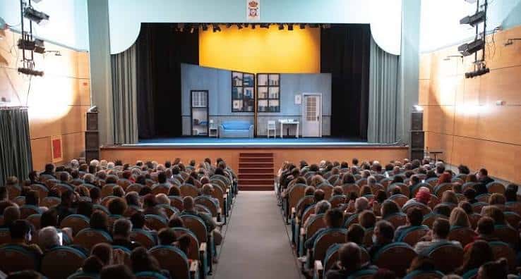 Interior del Teatro Municipal de San Bartolomé con escenario montado y público sentado