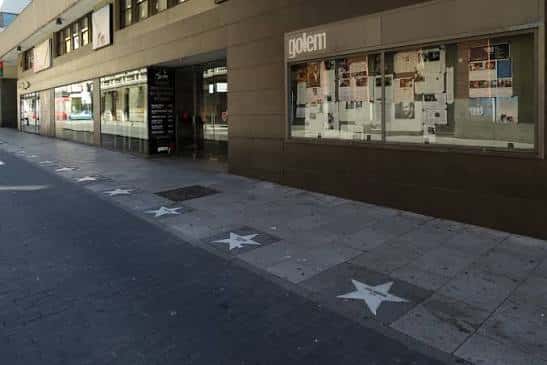 Vista exterior del Cine Golem en Madrid con fachada moderna y estrellas en el suelo