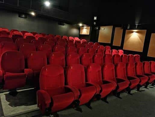 Interior de la sala de cine con butacas rojas dispuestas en filas