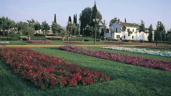Vista panorámica de los jardines con el edificio blanco al fondo