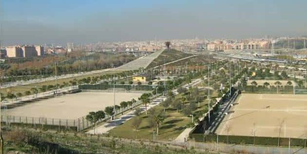 Panorámica amplia del parque mostrando zonas deportivas y la colina central con vistas a Madrid
