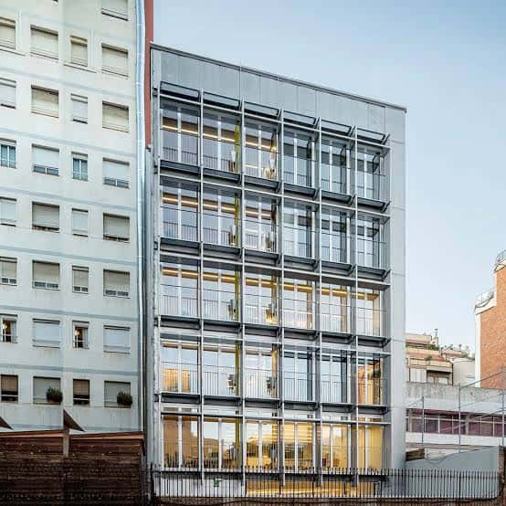 Vista exterior del edificio moderno con fachada de cristal y estructura metálica