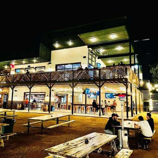 Fachada iluminada del establecimiento por la noche con terraza superior