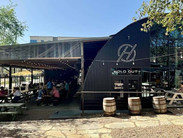 Vista exterior del Hold Out Brewing con su distintiva fachada curva y terraza al aire libre