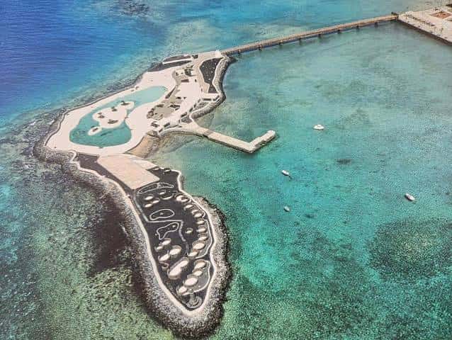 Vista cenital del islote mostrando la forma orgánica y los senderos entre rocas volcánicas