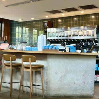 Barra de servicio con máquinas de café y decoración de azulejos verdes