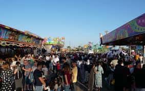 Vista panorámica del recinto ferial con atracciones y público durante la feria