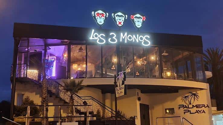 Fachada iluminada del restaurante Los 3 Monos por la noche