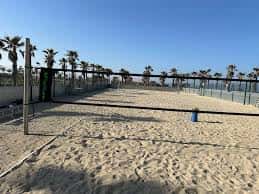 Pista de voleibol playa con red y arena en primer plano