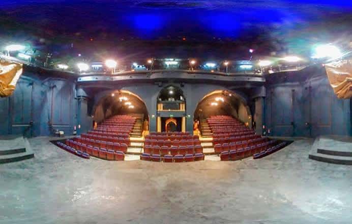 Vista panorámica del interior del Teatro de La Abadía con butacas rojas y escenario